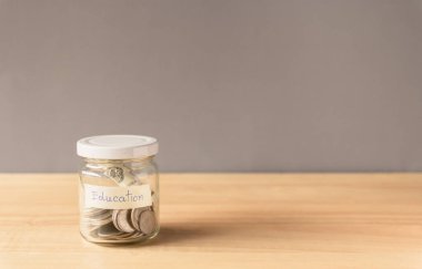 Para kavanozda, bozuk paralar da tahta zeminde.