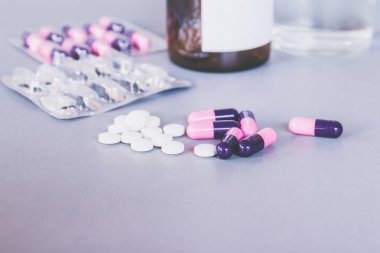 Beyaz arka planda haplar ve tabletler.