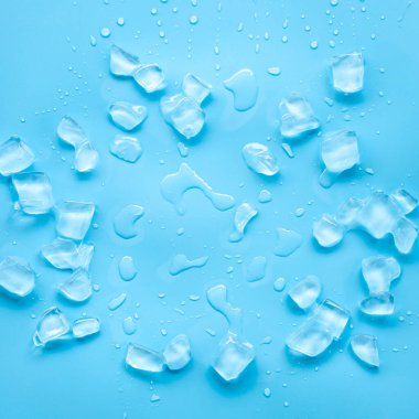 Mavi arkaplana dağılmış buz küpleri