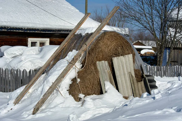 Haystack onder de sneeuw in het dorp — Stockfoto