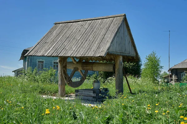 Alter hölzerner Dorfbrunnen mit Rad — Stockfoto