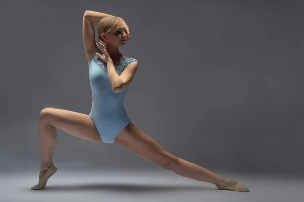 Mujer joven haciendo gimnasia en el fondo en el estudio — Foto de Stock