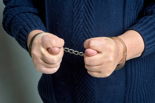 Mens hands in handcuffs show a fig — Stock Photo, Image