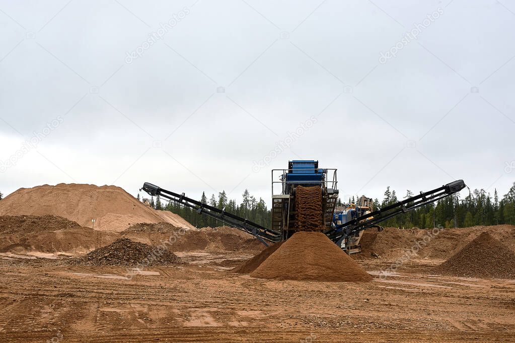 Mechanical machine for crushing stone with sand. Quarry for the extraction of crushed stone, sand and gravel
