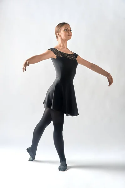 Una mujer de pie en una pose de baile sobre un fondo blanco — Foto de Stock