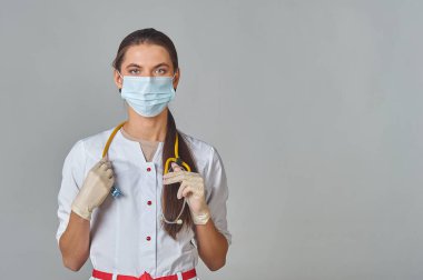 Tıbbi maskeli bir doktor ve steteskoplu beyaz önlüklü bir doktor.