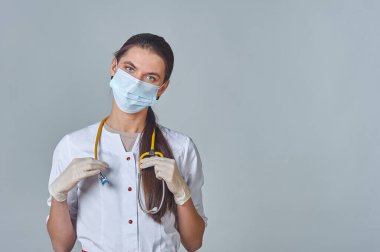 Tıbbi maskeli bir doktor ve steteskoplu beyaz önlüklü bir doktor.