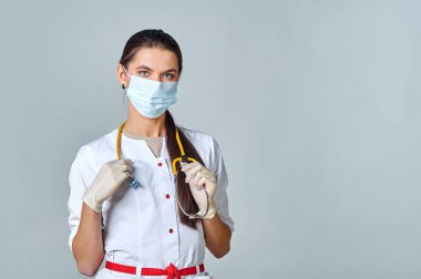 Tıbbi maskeli bir doktor ve steteskoplu beyaz önlüklü bir doktor.