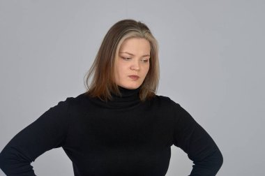 Siyah kazaklı genç bir kadın bir şey düşünüyor.