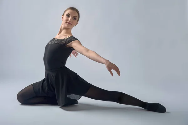 Балерина сидить на півкроці на фоні — стокове фото