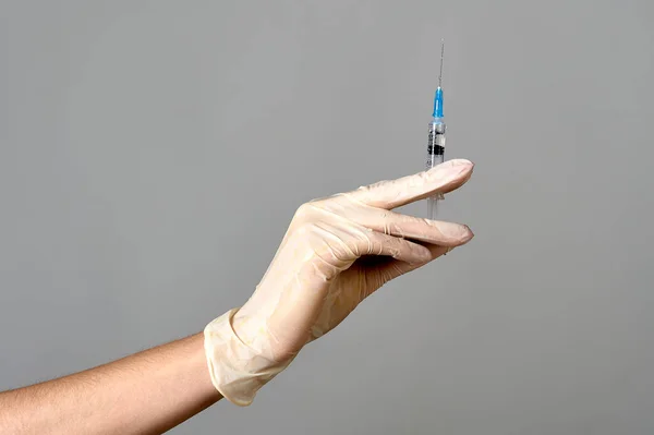 A mão de uma luva médica mantém uma seringa com a medicina, espaço de cópia — Fotografia de Stock