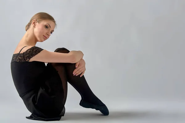 Ballerina Zit Achtergrond Met Haar Benen Tegen Haar Aan — Stockfoto