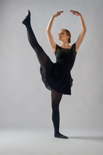 Балерина стоїть в позі ла Ренде на білому тлі — стокове фото
