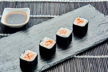 Baharatlı somon ruloları bir taş tezgahında