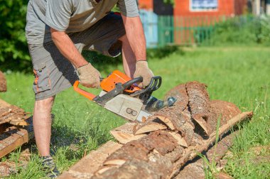 Yazın güneşli bir günde testere ile kereste kesiyorum.