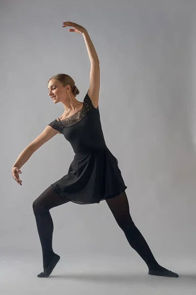 Le danseur se tient debout dans une pose sur un fond gris — Photo