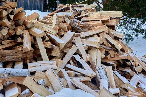 Ein Haufen gespaltenes Brennholz liegt im Winter auf dem Schnee — Stockfoto
