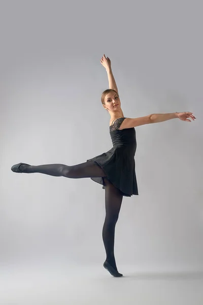 Jonge vrouw ballerina doen fouette op achtergrond — Stockfoto