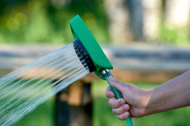 Hortumun ısısındaki bitkileri sulama kabı gibi hortumla sulamak.