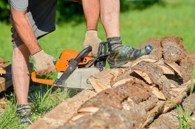 Yazın güneşli bir günde testere ile kereste kesiyorum.