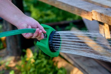 Hortumun ısısındaki bitkileri sulama kabı gibi hortumla sulamak.