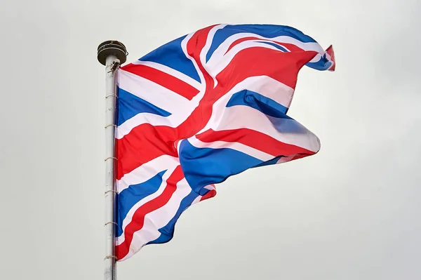 La bandera de Gran Bretaña ondea sobre el asta de la bandera —  Fotos de Stock