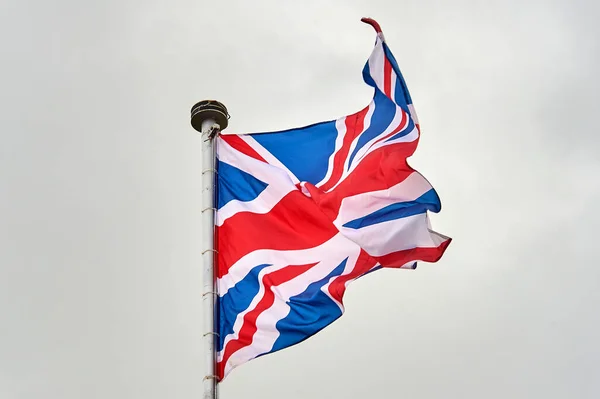 La bandera de Gran Bretaña ondea sobre el asta de la bandera —  Fotos de Stock