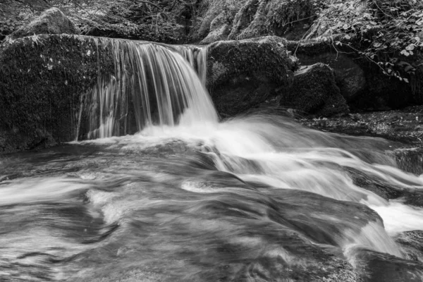 Hoar Oak Nehri 'nin üzerinde Exmoor Ulusal Parkı' ndaki Watersmeet 'te akan şelalenin uzun pozu.