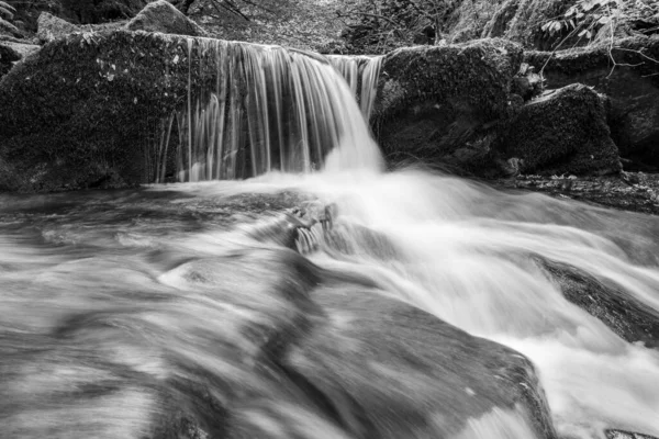 在Exmoor国家公园的Watersmeet 长时期暴露在Hoar Oak水河上流经树林的瀑布中 — 图库照片