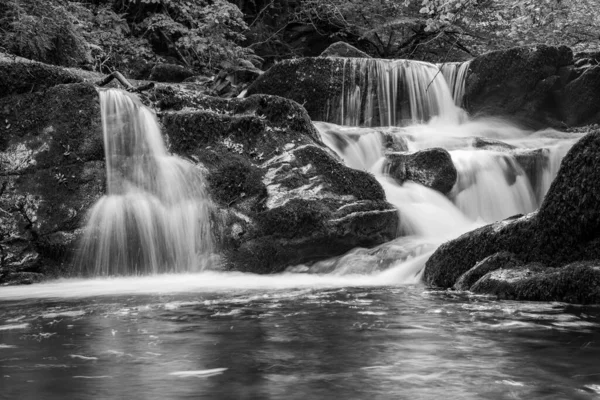 Exmoor国立公園のWatersmetで森を流れるHoar Oak Water川の滝の長い露出 — ストック写真