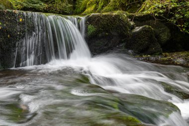 Hoar Oak Nehri 'nin üzerinde Exmoor Ulusal Parkı' ndaki Watersmeet 'te akan şelalenin uzun pozu.