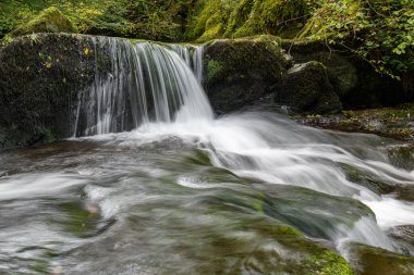 Hoar Oak Nehri 'nin üzerinde Exmoor Ulusal Parkı' ndaki Watersmeet 'te akan şelalenin uzun pozu.