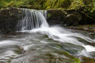 Hoar Oak Nehri 'nin üzerinde Exmoor Ulusal Parkı' ndaki Watersmeet 'te akan şelalenin uzun pozu.
