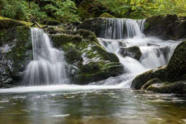 Hoar Oak Nehri 'nin üzerinde Exmoor Ulusal Parkı' ndaki Watersmeet 'te akan şelalenin uzun pozu.