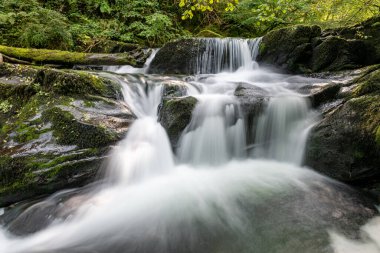 Hoar Oak Nehri 'nin üzerinde Exmoor Ulusal Parkı' ndaki Watersmeet 'te akan şelalenin uzun pozu.