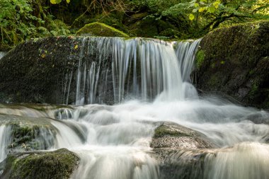 Hoar Oak Nehri 'nin üzerinde Exmoor Ulusal Parkı' ndaki Watersmeet 'te akan şelalenin uzun pozu.