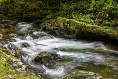Doğu Lyn nehrinin üzerinde Exmoor Ulusal Parkı 'ndaki Watersmeet' te akan şelalenin uzun pozu