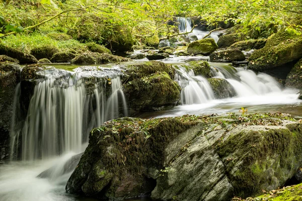 在Exmoor国家公园的Watersmeet 长时期暴露在Hoar Oak水河上流经树林的瀑布中 — 图库照片