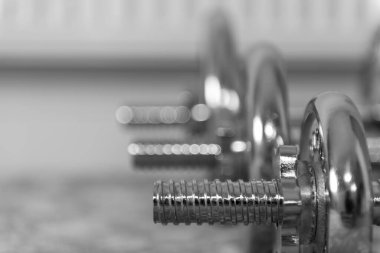 Evdeki bir sıra dambılın siyah beyaz fotoğrafı.