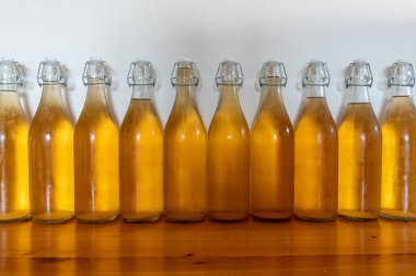 Bir sıra ev yapımı elma şarabı şişesini kapatın. Yoğunlaştırılmış elma şarabı.