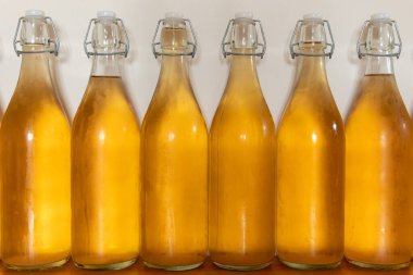 Bir sıra ev yapımı elma şarabı şişesini kapatın. Yoğunlaştırılmış elma şarabı.