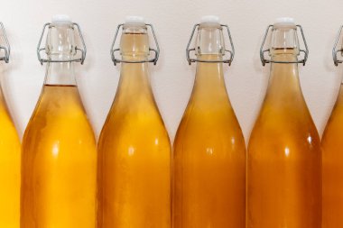 Bir sıra ev yapımı elma şarabı şişesini kapatın. Yoğunlaştırılmış elma şarabı.