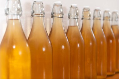 Bir sıra ev yapımı elma şarabı şişesini kapatın. Yoğunlaştırılmış elma şarabı.