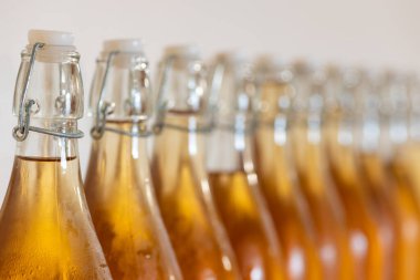 Bir sıra ev yapımı elma şarabı şişesini kapatın. Yoğunlaştırılmış elma şarabı.