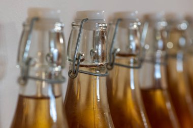 Bir sıra ev yapımı elma şarabı şişesini kapatın. Yoğunlaştırılmış elma şarabı.