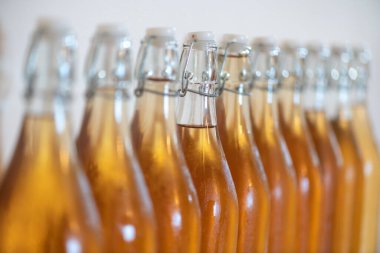 Bir sıra ev yapımı elma şarabı şişesini kapatın. Yoğunlaştırılmış elma şarabı.