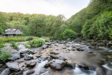 Doğu Lyn Nehri 'nin Exmoor Ulusal Parkı' ndaki Watersmeet Evi 'nin önünden akışı uzun sürdü.