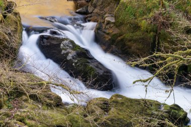 Doğu Lyn nehrinin üzerinde Exmoor Ulusal Parkı 'ndaki Watersmeet' te akan şelalenin uzun pozu