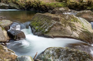 Doğu Lyn nehrinin üzerinde Exmoor Ulusal Parkı 'ndaki Watersmeet' te akan şelalenin uzun pozu
