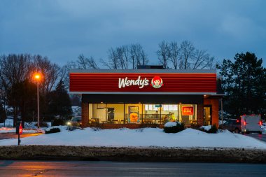 Yorkville, New York - 17 Aralık 2025: Wendy 'nin kış-beyaz elbisesiyle perakende satış yaptığı yeri gece görüşü. Wendy 's uluslararası bir fast food restoran zinciri.